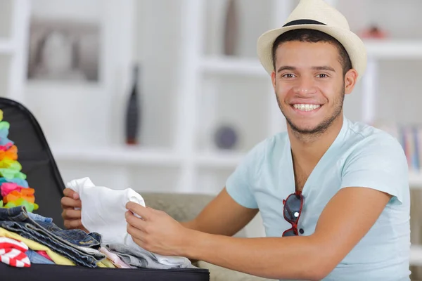 Evde Bavul Hazırlayan Mutlu Genç Adam — Stok fotoğraf