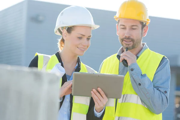 Collega Buiten Met Reflecterende Vesten Die Naar Tablet Kijken — Stockfoto