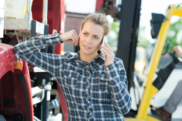 Mujer Hablando Teléfono Móvil Apoyada Equipo Pesado —  Fotos de Stock