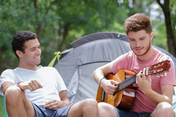 快乐的夫妇坐在帐篷附近用吉他 — 图库照片