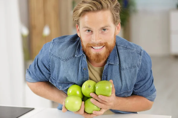 Man Dropping Armful Apples Worktop — Stock Photo, Image