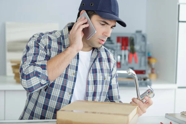 Telefondaki Tesisatçı Mutfaktaki Musluğu Tamir Ediyor — Stok fotoğraf