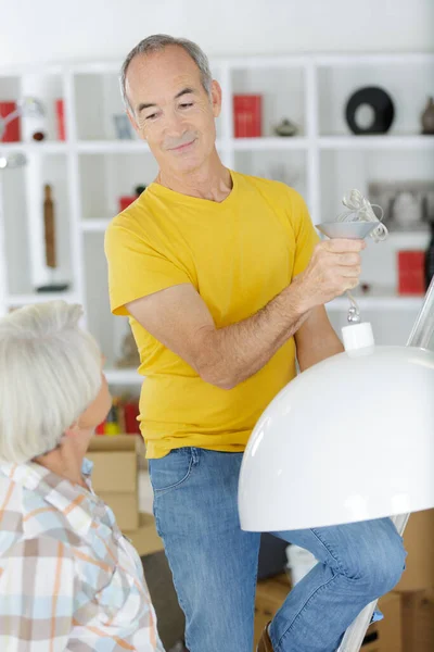 Senior Man Som Håller Hänge Lampa Hemma — Stockfoto