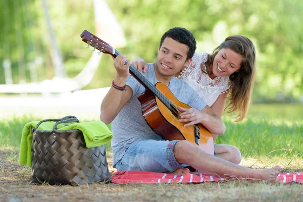 Młody Człowiek Dziewczyną Siedzi Kocu Piknikowym Gra Gitarze — Zdjęcie stockowe