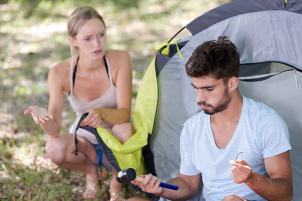 若い夫婦はテントを張るのに苦労して — ストック写真