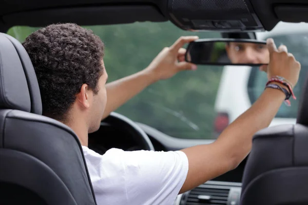 車のミラーを調整する男が — ストック写真