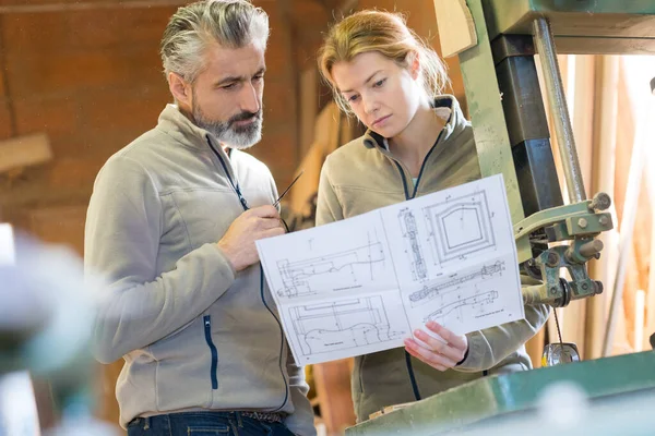 cabinet makers looking at project drawings