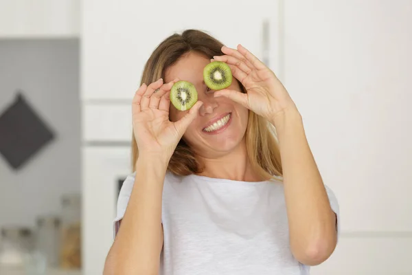 Beautiful Young Woman Holding Two Kiwis Her Eyes — Stock Photo, Image