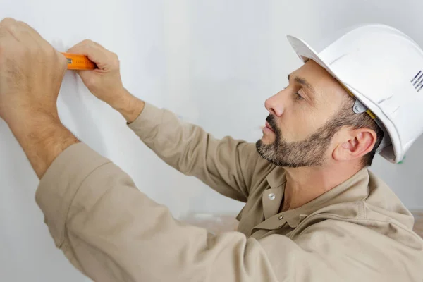 Mogen Manlig Byggare Med Hjälp Vattenpass Mot Väggen — Stockfoto