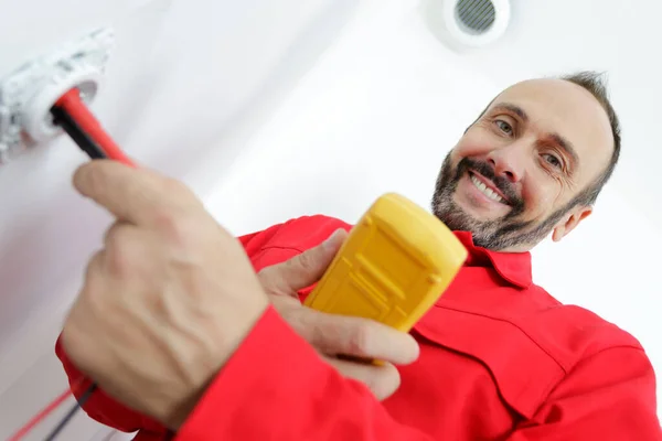 Felice Elettricista Controllo Della Tensione Nella Presa Elettrica Della Parete — Foto Stock