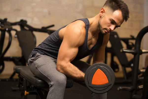 Joven Sentado Levantando Pesas Gimnasio — Foto de Stock