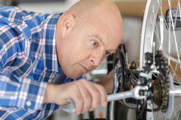 Medelålders Man Som Håller Skiftnyckel Och Reparerar Cykelhjul — Stockfoto