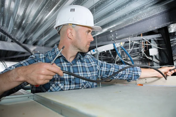Electrician Installing Cable Roof Space — Stockfoto