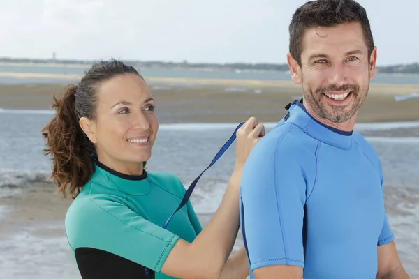 Ευτυχείς Surfers Ζευγάρι Στην Παραλία Βάζοντας Στολές — Φωτογραφία Αρχείου