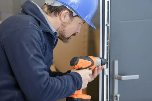 Man Drills Hole Door — Stockfoto