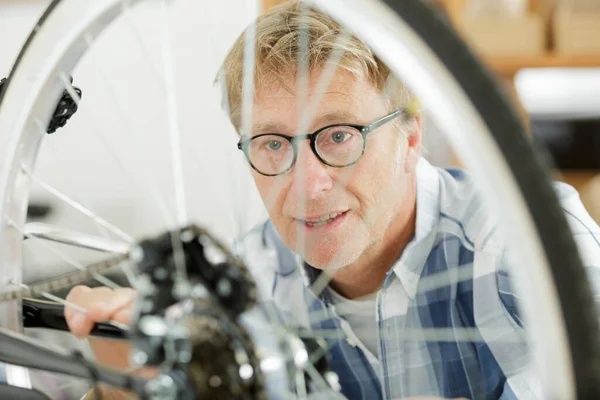 Mature Man Fixing Bike — Stockfoto