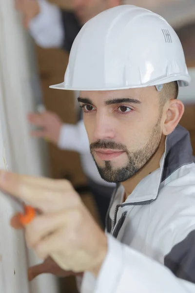 建筑工地的男性建筑工人检查墙 — 图库照片