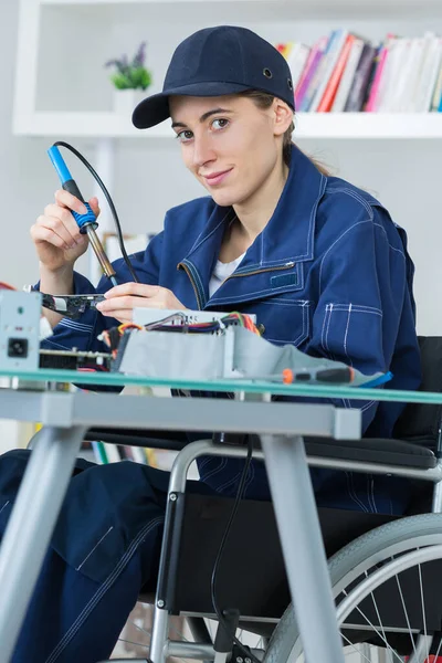 轮椅上的女技师焊接电路 — 图库照片