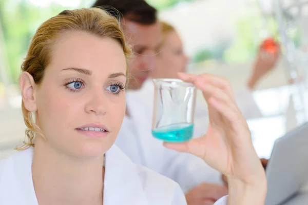 Tecnico Femminile Che Guarda Liquido Nel Bicchiere Vetro — Foto Stock