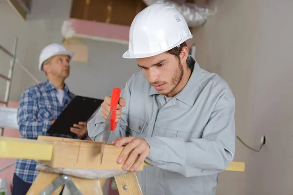 Trabalhador Construção Masculina Corte Madeira Com Serra Manual — Fotografia de Stock