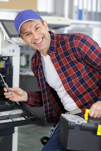 プリンターを修理する幸せな中年男性 — ストック写真