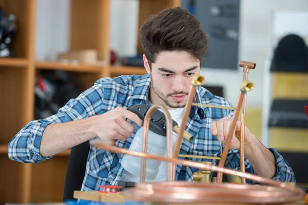 Genç Metal Işçisi Bakır Boruya Kaynak Makinesi Tutuyor — Stok fotoğraf