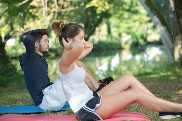 Casal Desportivo Fazendo Sit Ups Livre — Fotografia de Stock