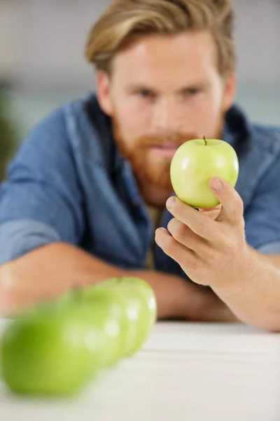 Kép Emberről Amint Egy Zöld Almát Néz — Stock Fotó