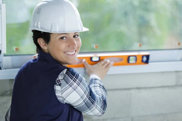 Gelukkig Vrouw Bouwer Meten Niveau Venster — Stockfoto