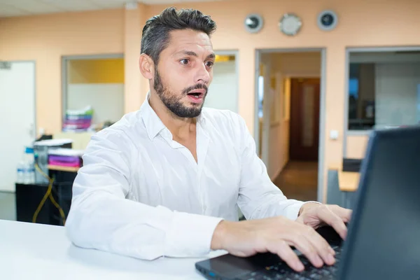 Chockad Man Med Bärbar Dator Sitter Vid Bord — Stockfoto