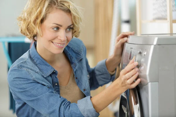 关闭一个操作洗衣机的女性 — 图库照片