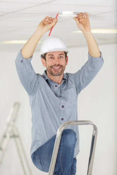 Mann Auf Der Leiter Installiert Eine Lampe — Stockfoto