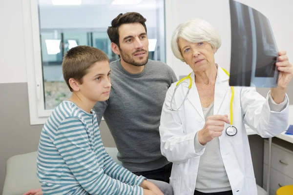 Médico Sênior Mostrando Xray Para Menino Pai — Fotografia de Stock