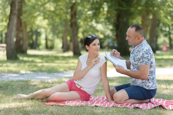 Parktaki Battaniyenin Üzerinde Çizim Defteri Olan Orta Yaşlı Bir Çift — Stok fotoğraf