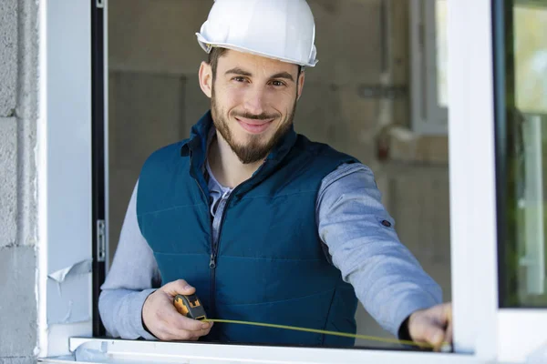 Glücklicher Bauarbeiter Beim Ausmessen Eines Fensters — Stockfoto