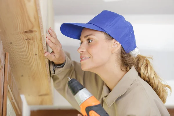 Woman Drilling Wood Plank Indoors — Stock Photo, Image