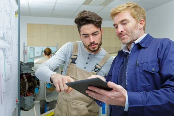 Két Munkás Egy Táblagéppel Egy Raktárban — Stock Fotó