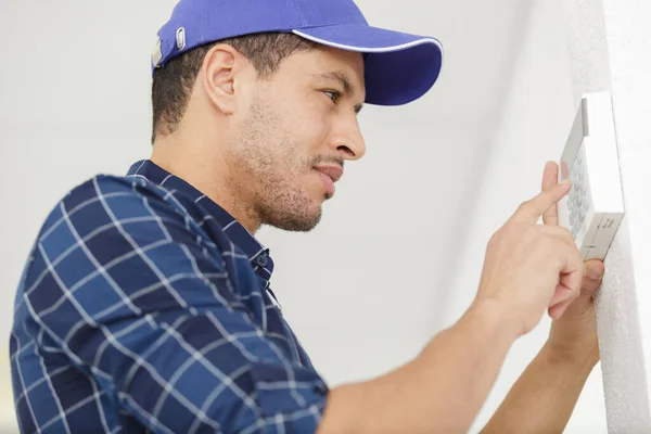 Jovem Encanador Fixando Termostato Casa — Fotografia de Stock