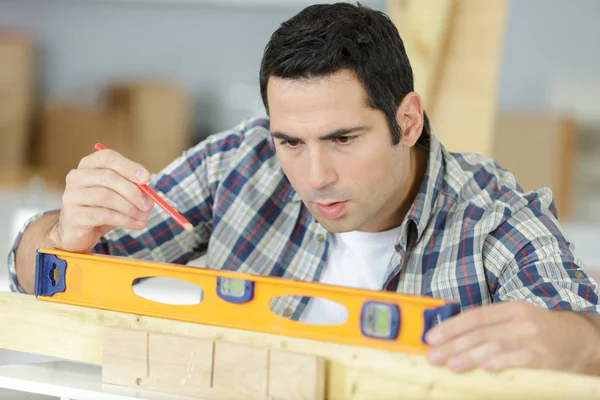 Mann Mit Wasserwaage Auf Holz — Stockfoto