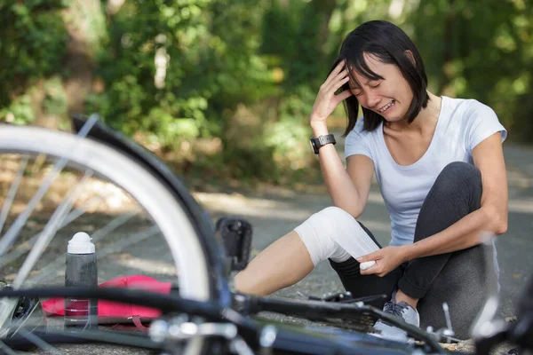 害怕的女人在撞坏的自行车旁哭泣 — 图库照片