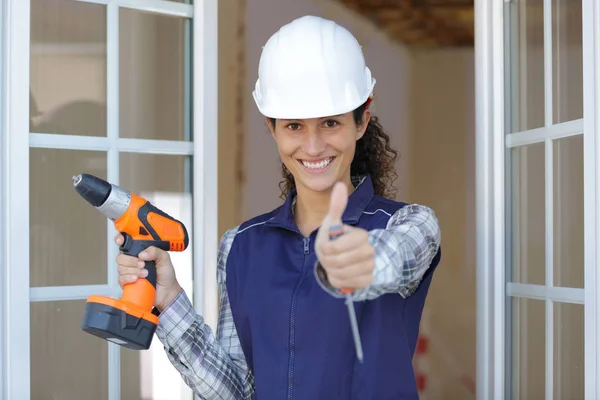 Feliz Trabajadora Sosteniendo Taladro Pulgar Hacia Arriba — Foto de Stock