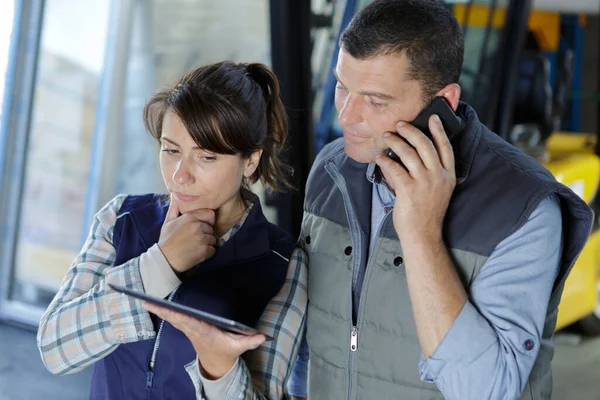Warehouse Worker Holding Tablet While Colleague Talking Phone — Stock Photo, Image