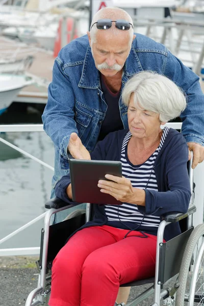 Man Oudere Vrouw Een Rolstoel Met Behulp Van Een Tablet — Stockfoto