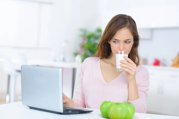 Vrouw Controleren Haar Laptop Tijdens Het Drinken Van Melk — Stockfoto