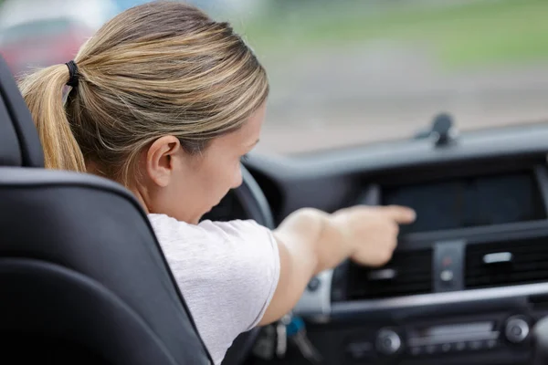 車のダッシュボードで女性の指を押すボタン — ストック写真