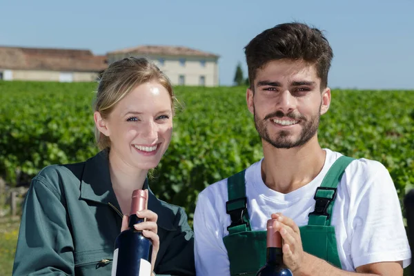 Üzüm Tarlalarında Ellerinde Şarap Şişeleriyle Mutlu Bir Çift — Stok fotoğraf