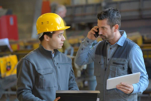 Manlig Handledare Talar Mobiltelefon Med Arbetstagare Industrin — Stockfoto