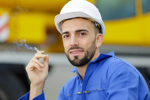 建設現場でタバコを吸う幸せなビルダー — ストック写真