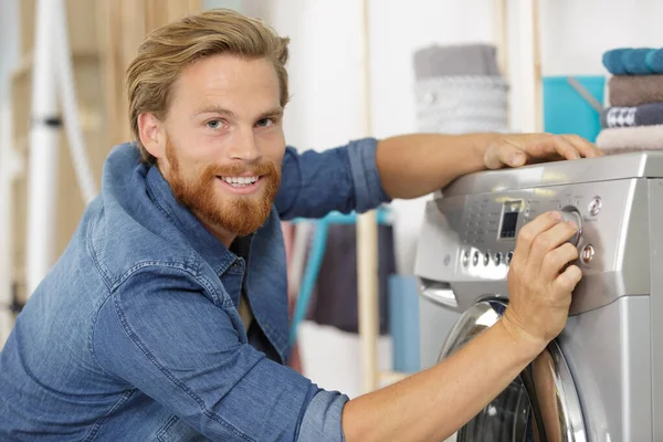 Junger Mann Lädt Kleidung Küche Waschmaschine — Stockfoto