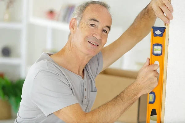 Senior Mitarbeiter Überprüfen Das Niveau Der Wand — Stockfoto